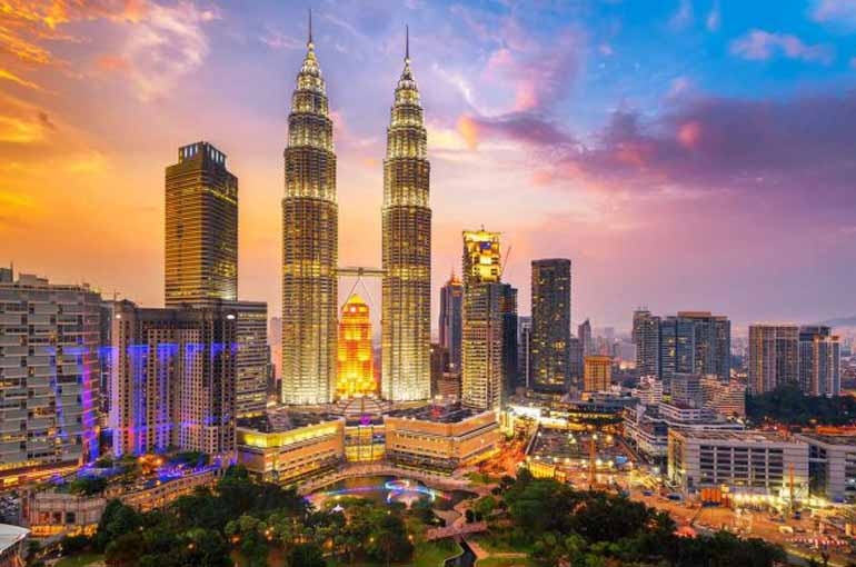 از جنگل های انبوه شهری کوالالامپور (Kuala Lumpur) گرفته تا سواحل بکر جزایر پرهنتیان (Perhentian)، مالزی کشوری زیباست که اغلب دست کم گرفته شده. اگر قصد سفر به مالزی دارید حتما این مطلب را بخوانید. می توانید یک روز را با قبایل بومی مالزی یا در مزارع کشت چای کامرون (Cameron Highland) بگذرانید یا در پارک ملی عظیم گونونگ مولو (Gunung Mulu) و تامان نیگارا (Taman Negara) پیاده روی کنید و همزمان با حیات وحش آن مثل پلنگ و اورانگوتان روبرو شوید. حتما سری هم به بورنئو (Borneo) بزنید و از جنگل آن بازدید کنید و در سیپادان (Sipadan) که یکی از بهترین نقاط دنیا برای غواصی است تنی به آب بزنید. همچنین غذاهای هندی و انواع کاری در این کشور به وفور یافت می شود. مالزی یک تجربه ویژه است و با کشورهای همسایه خود خیلی متفاوت است. مطلب پیشنهادی: معروفترین جاذبه های گردشگری مالزی (Malaysia) هزینه های معمول در سفر به مالزی (Malaysia) هزینه هتل و هاستل در مالزی هزینه هتل و هاستل در مالزی هزینه خوابگاه ها در مالزی از شبی 30 تا 55 رینگیت متغیر است، در شهرهای بزرگ معمولا این رقم حدود 55 رینگیت است. اتاق های خصوصی چیزی حدود 75 رینگیت برای تخت یک نفره و صد رینگیت برای تخت دونفره است. هتل های ارزان قیمت مالزی هم از شبی 80 رینگیت شروع می شوند. هزینه غذا در مالزی هزینه غذا در مالزی غذاهای خیابانی در مالزی معمولا از کمتر از 4 رینگیت شروع می شوند و به ندرت به بیش از 11 رینگیت می رسند. در رستوران های مالزی هم باید بین 7 تا 20 رینگیت بپردازید. غذاهای غربی همیشه گرانتر در می آیند. هزینه حمل و نقل در مالزی هزینه حمل و نقل در مالزی هزینه سفر با اتوبوس در مالزی مبلغی بین 5 تا 11 رینگیت برای هر ساعت است. تاکسی در مالزی گرانتر است چون کرایه بر اساس هر نفر حساب می شود و اگر با خود همراه نداشته باشید باید کرایه چهار نفر را حساب کنید! کرایه ها در کوالالامپور (Kuala Lumpur) از 3 رینگیت برای 6 مایل شروع می شوند. البته خیلی تاکسی ها فاقد تاکسی متر هستند. بهتر است در این شرایط همان اول سر قیمت به توافق برسید. مطلب پیشنهادی: راهنمای خرید بلیط هواپیما ارزان (پرواز) برای سفرهای خارجی هزینه تفریح و فعالیت های مختلف در مالزی هزینه فعالیت های مختلف در مالزی اغلب جاذبه های گردشگری مالزی (Malaysia) کاملا ارزان هستند. کوهپیمایی روزانه بین 35 تا 75 رینگیت هزینه دارد. غواصی در مالزی برای دو روز بین 245 تا 300 رینگیت و برای یک دوره کامل آموزشی از 830 تا 1325 رینگیت است. مطلب پیشنهادی: دیدنی های مالزی را بشناسید نکاتی برای کم کردن هزینه ها در مالزی تاکسی ها در مالزی تاکسی ها در مالزی تاکسی ها در مالزی معمولا فاقد تاکسی متر هستند، پس حتما قبل از حرکت درباره کرایه به توافق برسید. کمپینگ در مالزی کمپینگ در مالزی برای کم کردن هزینه اسکان در مالزی، می توانید در تامان نگارا (Taman Negara) کمپ بزنید، البته باید حدود 5 رینگیت بپردازید. غذاهای محلی خیابانی مالزی غذاهای محلی خیابانی مالزی دستفروشان مالزی غذاهای خوشمزه ای را که فقط چند دلار هستند در غرفه های خیابانی می فروشند. به عقیده بعضی ها، آنها بهترین و ارزانترین غذاهای مالزی هستند. مطلب پیشنهادی: 12 کاری که نباید در سفر انجام داد تجربه هایی که نباید در مالزی (Malaysia) از دست بدهید 1) بازدید از کوالالامپور (Kuala Lumpur) بازدید از کوالالامپور (Kuala Lumpur) احتمال اینکه چند شبی را در پایتخت مالزی، کوالالامپور بگذرانید زیاد است. بازدید از برج های دوقلو پیتروناس (Petronas Twin Towers) را از دست ندهید. اگر از ارتفاع نمی ترسید، روی پلی که این دو را به هم وصل می کند قدم بزنید. ارتفاع آنها 1500 فوت هست. یک باغ پرندگان و چند پارک هم هست که ارزش دیدن را دارد. مطلب پیشنهادی: 10 مکان دیدنی برتر کوالالامپور (Kuala Lumpur) 2) غواصی در جزایر پرهنتیان (Perhentian Islands) غواصی در جزایر پرهنتیان (Perhentian Islands) این جزایر مالزی طرفدارن زیادی میان غواصان دارد چون صخره های مرجانی و آب شفاف اطراف آنها، میزبان گونه های متفاوت مرجان، لاک پشت دریایی و کوسه های کوچک و ماهی مرجانی است. مطلب پیشنهادی: جزایر مالزی را بشناسید 3) کوهپیمایی در پارک ملی کینابالو (Kinabalu) کوهپیمایی در پارک ملی کینابالو (Kinabalu) پارک ملی کوتا کینابالو (Kota Kinabalu) بخاطر ارزش های جهانی برجسته اش، به عنوان اولین میراث جهانی مالزی در سال 2000 شناخته شد. اگر در بازدید خود به دنبال چیز ویژه ای هستید، از آنجا دست خالی بر نمی گردید. کوه کوتا کینابالو (Kota Kinabula) بلندترین کوه مالزی و چهارمین کوه بلند آسیای جنوب شرقی است. کوهپیمایی در این پارک عظیم (با مساحت بیش از 600 مایل مربع) فوق العاده است. مطلب پیشنهادی: دیدنی های کوتاکینابالو (Kota Kinabalu) 4) تجربه تنوع در پارک فرهنگی ساراواک (Sarawak Cultural Village) تجربه تنوع در پارک فرهنگی ساراواک (Sarawak Cultural Village) این موزه زنده، میراثی از تمام اقوام نژادی را در مالزی (Malaysia) به نمایش می گذارد، مالایی ها، چینی ها و هندی ها سالیان دراز است که به طور مسالمت آمیز در کنار هم زندگی می کنند. در کنار این تجربه فرهنگی، فعالیت های عجیب و جالبی مثل بولینگ با نارگیل، تیراندازی با فوت کردن در لوله یا کلاس های رقص سنتی هم برگزار می شود. مطلب پیشنهادی: 10 مقصد برتر مالزی 5) حیات وحش مالزی حیات وحش مالزی کشور مالزی هم روی زمین و هم در آب های اطراف خود حیات وحش غنی دارد. بعضی از جانوران نادر و در معرض خطر دنیا در این کشور وجود دارند. اورانگوتان ها، پلنگ های مالزیایی، مارمولک مانیتور و کرگدن سوماترایی همگی از حیوانات بومی این کشور هستند و در خیلی از تورهای حیات وحش مالزی قابل مشاهده هستند. مطلب پیشنهادی: پارک های ملی جهان را بشناسید 6) غواصی در جزیره سیپادان (Sipadan) غواصی در جزیره سیپادان (Sipadan) جزیره سیپادان (Sipadan) یکی از بهترین نقاط جهان برای غواصی است. آبهای شفاف این منطقه پر از کوتر ماهیان، سفره ماهی دیو، کوسه ماهی سرچکشی، کوسه نهنگ، لاک پشت پشت سبز و پوزه عقابی است. به قول ژاک ایو کوستو (Jacques Cousteau): « یک اثر هنری دست نخورده» مطلب پیشنهادی: بهترین نقاط جهان برای غواصی 7) گردش در مزارع کشت چای کامرون گردش در مزارع کشت چای کامرون ارتفاعات کامرون (Cameron Highlands) پوشیده از کشتزارهای سبز چای و محلی پرطرفدار برای گردشگری است. برای آشنایی با فرآیند تولید چای می توانید از کارخانجات آنجا بازدید کنید و یا با یک فنجان چای با کیک یا کلوچه اجباری به استراحت بپردازید. این منطقه برای وقت گذرانی و فرار از گرمای حاکم بر بقیه نقاط کشور مالزی و پیاده روی محشر هست. 8) بازدید از جورج تاون (Georgetown) بازدید از جورج تاون (Georgetown) از جورج تاون (Georgetown) اغلب به عنوان جذاب ترین شهر مالزی یاد می شود؛ شهری پر از مغازه های شلوغ و شب های محشر. این شهر در سال 2008 به عنوان میراث جهانی مالزی در یونسکو (UNESCO) ثبت شد و روز به روز هم به شهرت آن افزوده می شود. مطلب پیشنهادی: دیدنی های جورج تاون (Georgetown) 9) تجربه ای هیجان انگیز در پارک ملی تامان نگارا (Taman Negara) تجربه ای هیجان انگیز در پارک ملی تامان نگارا (Taman Negara) پارک ملی تامان نگارا (Taman Negara) با سن تخمینی 130 میلیون سال، قدیمی ترین جنگل بارانی دنیا و بزرگترین جنگل مالزی محسوب می شود. در این مکان فعالیت های زیادی مثل پیاده روی روی پل معلق، سافاری با ماشین شاسی بلند، اکتشاف غارها و کوهپیمایی انجام می شود. 10) تریشا سواری (Trishaw) در ملاکا تریشا سواری (Trishaw) در ملاکا تریشا یک شیوه متفاوت حمل و نقل هست که می توانید در سراسر ملاکا (Melaka) ببینید. این تاکسی های ساده دوچرخه مانند، پر از تزیینات هستند و بعضی از آنها موسیقی تکنو پخش می کنند. راننده ها انگار همگی در یک مسابقه با هم رقابت می کنند و این دلیل عمده به جود آمدن تاکسی های رنگارنگ و خلاقانه شده است. مطلب پیشنهادی: راه های کسب درآمد در سفر 11) گشتی در کوتا بارو (Kota Bharu) گشتی در کوتا بارو (Kota Bharu) شهر کوتابارو (Kota Bharu) که به شهر «اسلامی» هم شهرت دارد قصرهای پادشاهی، تعدادی موزه و بازارهای محلی جالبی دارد. این منطقه برای شب مانی فوق العاده است. مطلب پیشنهادی: دیدنی های کوتا بارو (Kota Bharu) 12) استراحت در پولا لنکاوی (Pulau Langkawi) استراحت در پولا لنکاوی (Pulau Langkawi) اکثر مردم وقتی مالزی را تصور می کنند جزیره لنکاوی (Langkawi) در ذهنشان تداعی می شود. این جزیره که در مجلات، وبسایت ها و مقالات و... زیادی به تصویر کشیده می شود، یکی از جاذبه تفریحی جذاب مالزی با سواحل زیبا و آفتاب زیاد است. در لنکاوی رستوران های زیاد، جاهای دیدنی و روستاهای جالبی برای بازدید وجود دارد. مطلب پیشنهادی: جزیره لنکاوی (langkawi) را بیشتر بشناسید 13) بازدید از ایپو (Ipoh) بازدید از ایپو (Ipoh) ایپو (Ipoh) یکی از بزرگترین شهرهای مالزی و میزبان رستوان های بسیار خوب مالزی و مکان های دیدنی جالبی است. چند موزه و چند جاذبه تاریخی مالزی مثل برج ساعت یابود جیمز بیرچ (Birch Memorial Clock Tower) و چند معبد هم در آنجا وجود دارد. 14) رودخانه گردی در مالزی رودخانه گردی در مالزی به غیر از غواصی، مالزی بخاطر وجود آب های خروشان و رودخانه هایش هم مشهور است. قیمت رفتینگ در رودخانه های مالزی از حدود 190 رینگیت شروع می شود. 15) آشنایی با ریشه های استعماری مالزی در ملاکا آشنایی با ریشه های استعماری مالزی در ملاکا مالزی پیشینه استعماری مختلفی دارد، تا پیش از کسب استقلال، اول به دست پرتغالی ها، هلندی ها و بعد انگلیسی ها افتاد. برای درک بهتر تاثیر استعمار، سری به ملاکا (Melaka) بزنید. این شهر در سال 2008 به عنوان میراث جهانی مالزی در یونسکو (UNESCO) ثبت شد و پر از موزه، اماکن و معابد جالب برای بازدید هست.